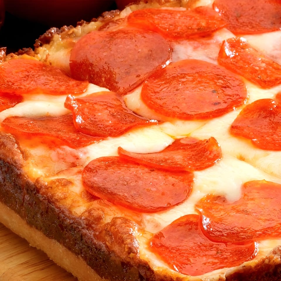 Close-up of a Mancino's of Taylor deep-dish pepperoni pizza with melted cheese and crispy crust.